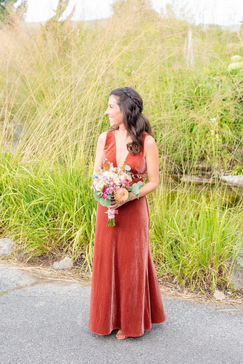 Photos at New Jersey wedding venue, Crystal Springs Resort, in Hamburg with an outdoor ceremony option and indoor reception, by Mikkel Paige Photography. The Maid of Honor wore an orange rust colored velvet gown. She carried colorful bouquets. #mikkelpaige #CrystalSprings #NJweddingvenues #NewJerseyWedding #NJweddingphotographer #fallwedding #velvetdress #rustgown #weddingparty #bridalparty #maidofhonor #bridesmaid #colorfulbouquet