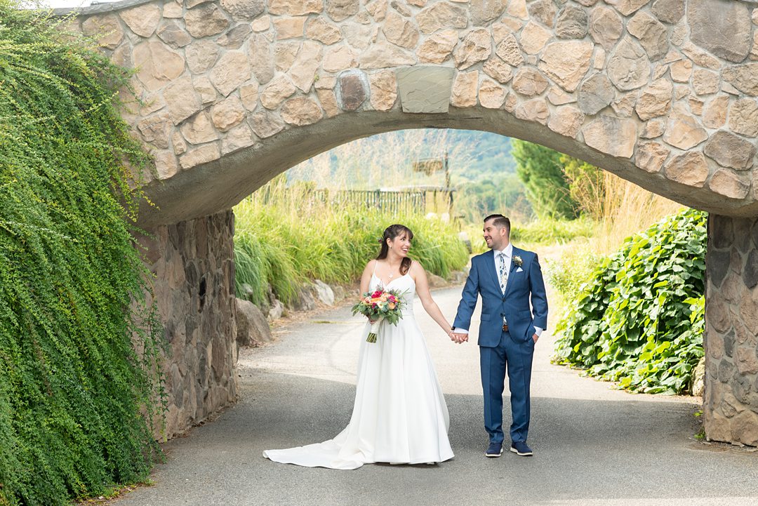 New Jersey wedding venue, Crystal Springs Resort, in Hamburg with an outdoor ceremony option and indoor reception. Photos by Mikkel Paige Photography. The bride wore a simple classic white dress with flowers in her hair and groom a blue suit and floral tie. #mikkelpaige #CrystalSprings #NJweddingvenues #NewJerseyWedding #NJweddingphotographer #brideandgroom