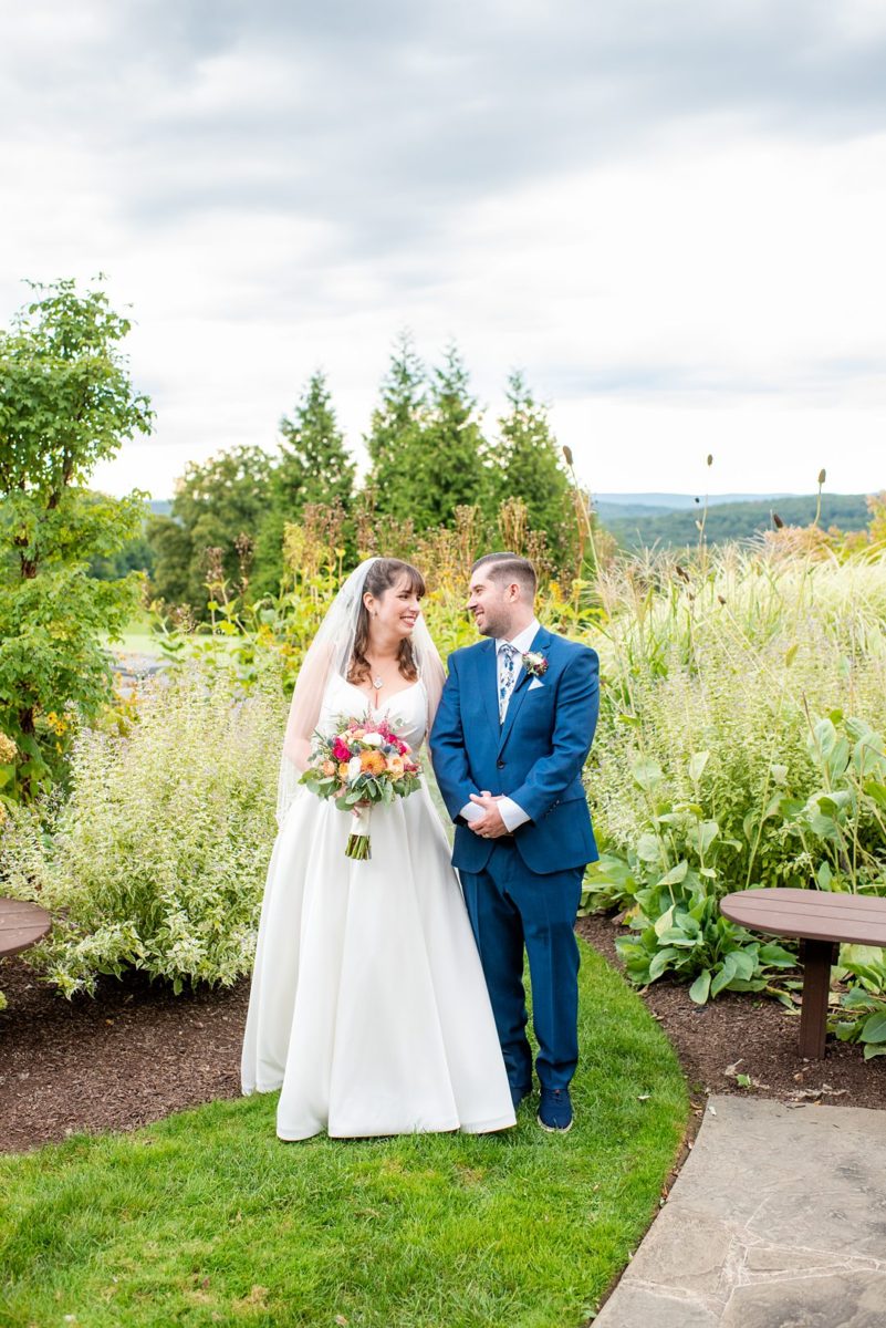 New Jersey wedding venue, Crystal Springs Resort, in Hamburg with an outdoor ceremony option and indoor reception. Photos by Mikkel Paige Photography. The bride wore a simple classic white dress with flowers in her hair and groom a blue suit and floral tie. #mikkelpaige #CrystalSprings #NJweddingvenues #NewJerseyWedding #NJweddingphotographer #brideandgroom