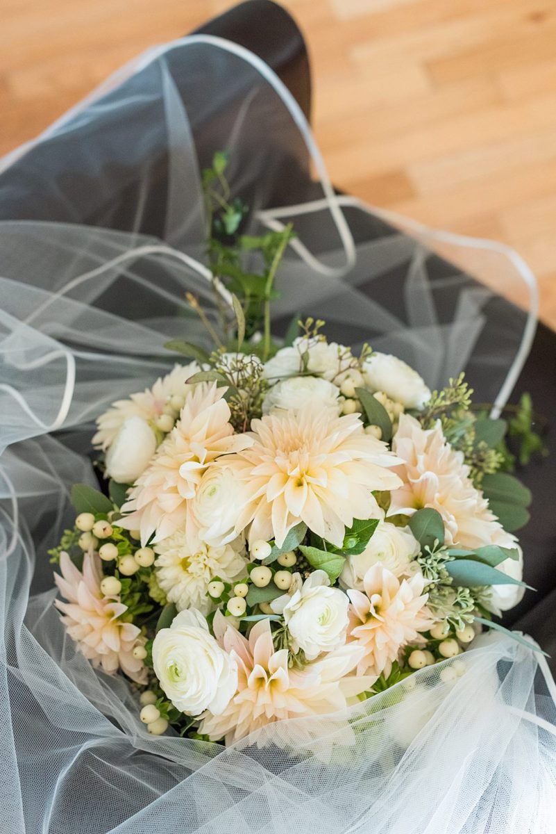 Fall bouquet with dahlias, ranunculus and berries in white, ivory and peach with ivy for a wedding in upstate New York, just outside NYC, in Chappaqua, Westchester County. The wedding at Crabtree's Kittle House had an outdoor ceremony then reception indoors. It was filled with pumpkins, autumn leaves, orange, white, and peach colors. Bouquet photo taken by Mikkel Paige Photography with ivy and dahlias. #mikkelpaige #fallwedding #newyorkweddingvenues #nycweddingphotographer #bridestyle #autumnwedding #fallbouquet