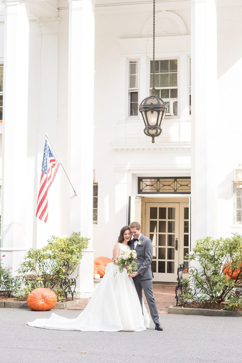 Photographs were taken by Mikkel Paige Photography for a fall wedding in upstate New York, just outside NYC, in Chappaqua, Westchester County. The bride and groom got married at Crabtree's Kittle House outdoors with an indoor reception. It was filled with pumpkins, autumn leaves, orange, white, peach and navy colors. The bride's gown had a long train and back bow. #mikkelpaige #fallwedding #newyorkweddingvenues #upstatenewyorkweddingvenues #nycweddingphotographer #BrideStyle #autumnbouquet