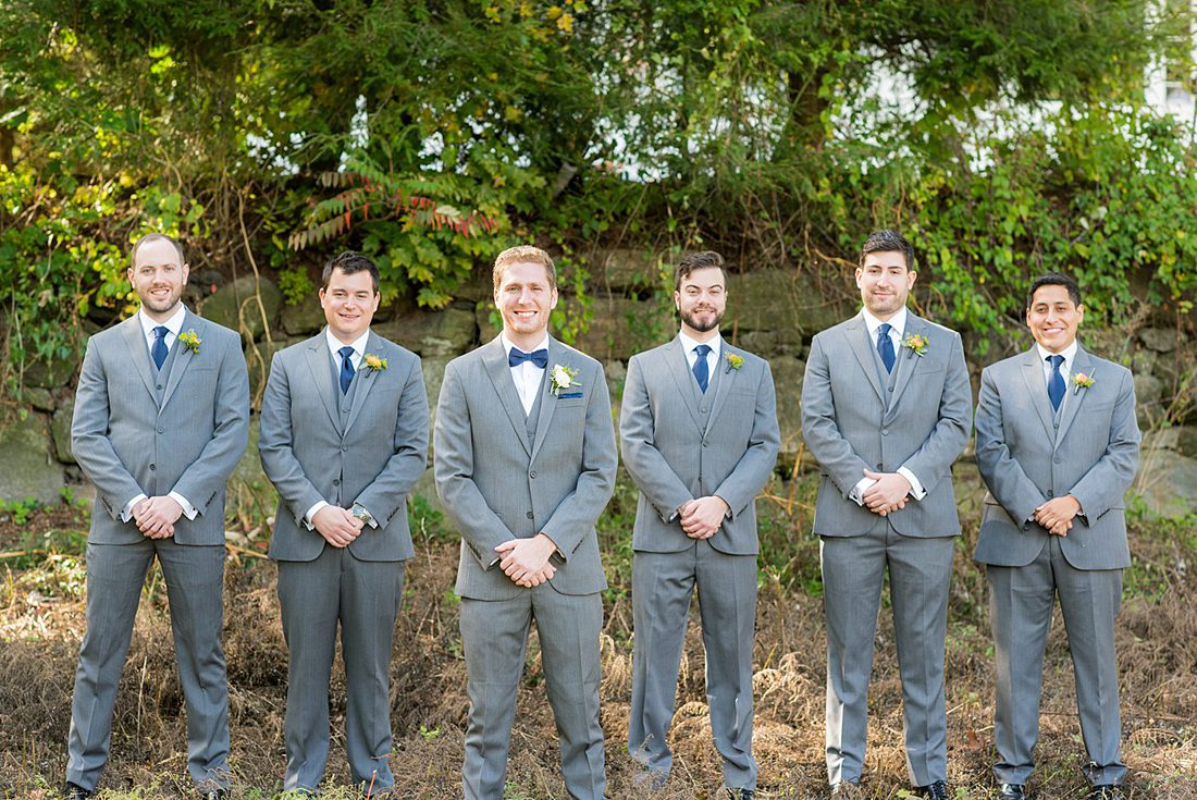 Groomsmen dressed in grey suits for a fall wedding in upstate New York, just outside NYC, in Chappaqua, Westchester County. The wedding at Crabtree's Kittle House had an outdoor ceremony then reception indoors. It was filled with pumpkins, autumn leaves, orange, white, and peach colors. Photos taken by Mikkel Paige Photography. #mikkelpaige #fallwedding #newyorkweddingvenues #nycweddingphotographer #outdoorceremony #greygroomsmen #autumnwedding