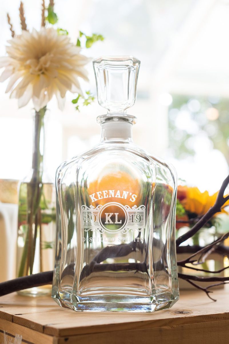 Custom engraved decanters from the groom to his groomsmen for a fall wedding in upstate New York, just outside NYC, in Chappaqua, Westchester County. The wedding at Crabtree's Kittle House had an outdoor ceremony then reception indoors. It was filled with pumpkins, autumn leaves, orange, white, and peach colors. Detail photo taken by Mikkel Paige Photography. #mikkelpaige #fallwedding #newyorkweddingvenues #nycweddingphotos #outdoorceremony #autumnwedding ##groomstyle #groomsmengift #decanters