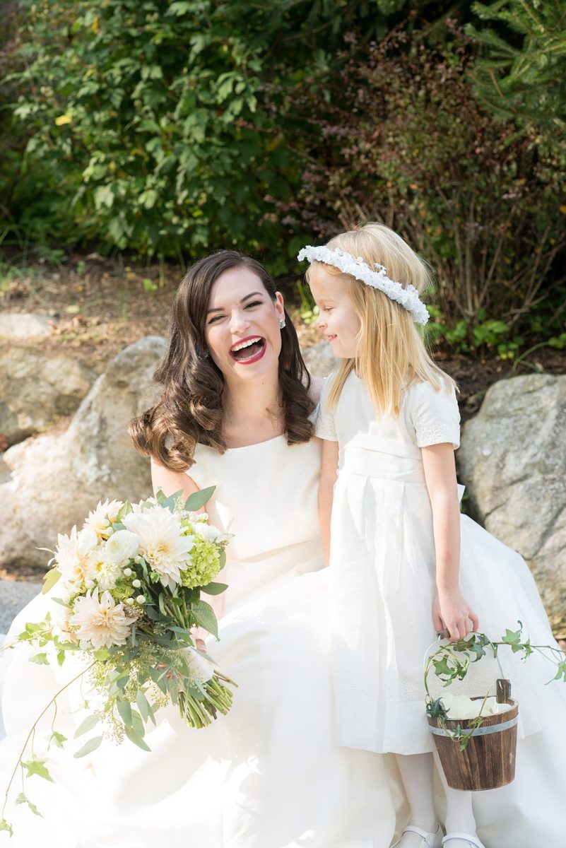 Fall wedding in upstate New York, just outside NYC, in Chappaqua, Westchester County. This bride and groom got married at Crabtree's Kittle House outdoors, then celebrated inside for their reception. It was filled with pumpkins, autumn leaves, orange, white, peach and navy colors. Photo taken by Mikkel Paige Photography of the bride and her flower girl. #mikkelpaige #fallwedding #newyorkweddingvenues #upstatenewyorkweddingvenues #nycweddingphotographer #flowergirl