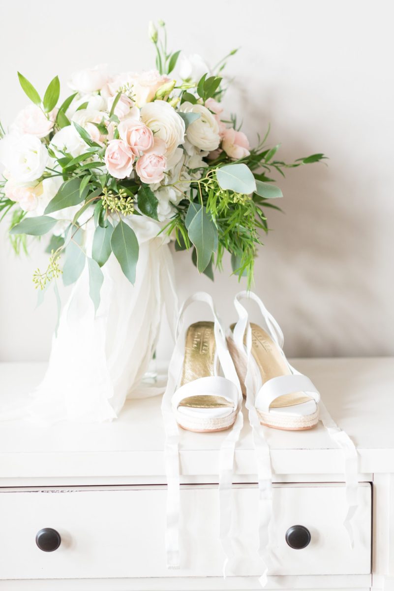 A detail picture of the brides white wedge heels she wore for her wedding day and reception on a tented lawn. Their Saratoga Springs destination wedding photos in upstate New York are by Mikkel Paige Photography, NY wedding photographer. #mikkelpaige #saratogaspringswedding #destinationwedding #bridalparty #bohobride #wedges #bridalshoes #bridestyle