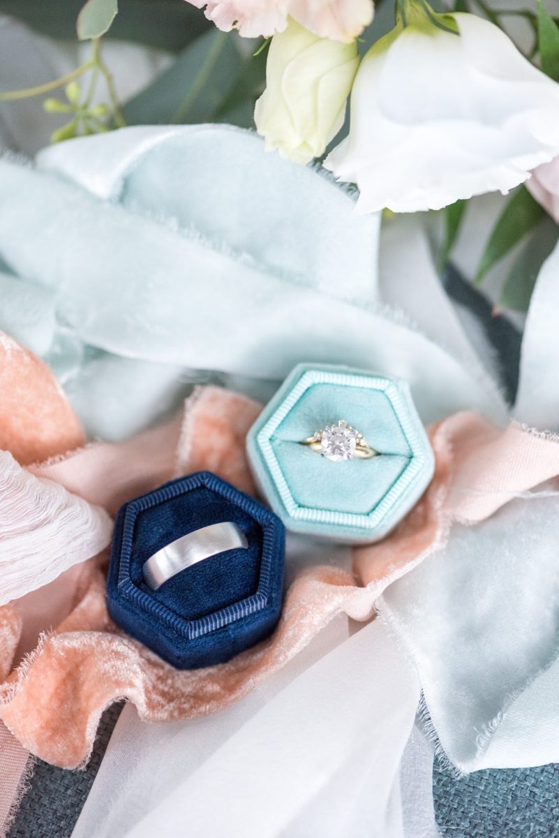 Saratoga Springs destination wedding photos in upstate New York by Mikkel Paige Photography, NY wedding photographer. This picture is of the bride and groom's wedding bands and engagement ring with blue velvet ring boxes. #mikkelpaige #saratogaspringswedding #destinationwedding #velvetringboxes #weddingrings #uniqueweddingrings #uniqueweddingband