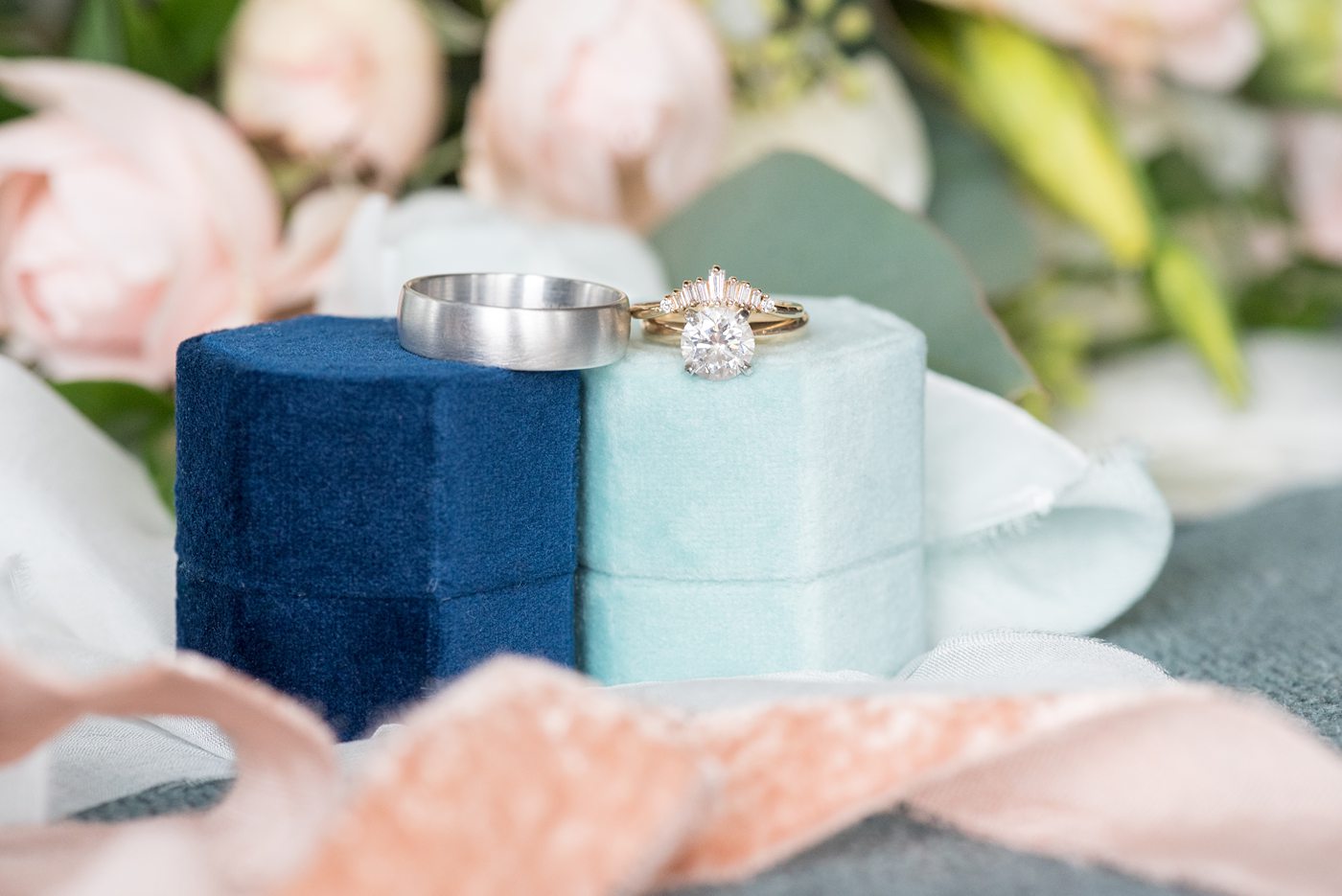 Saratoga Springs destination wedding photos in upstate New York by Mikkel Paige Photography, NY wedding photographer. This picture is of the bride and groom's wedding bands and engagement ring with blue velvet ring boxes. #mikkelpaige #saratogaspringswedding #destinationwedding #velvetringboxes #weddingrings #uniqueweddingrings #uniqueweddingband