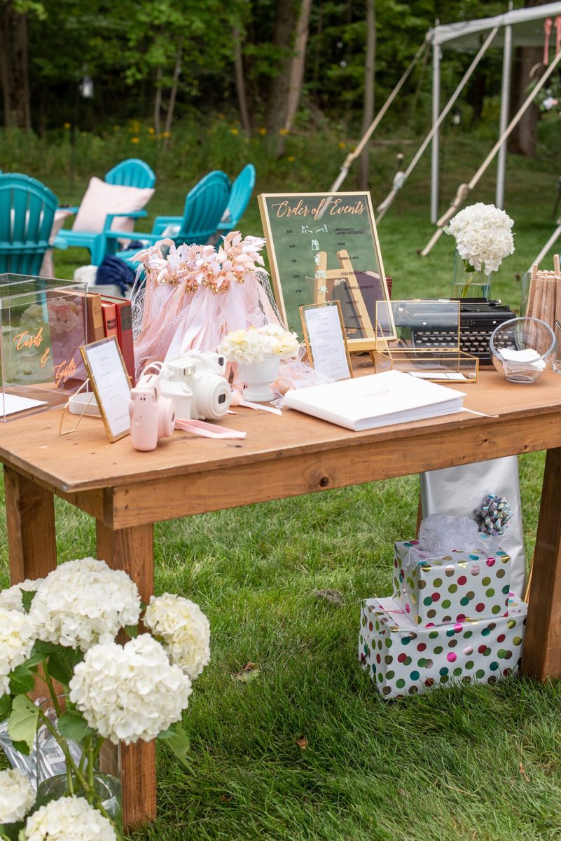 Saratoga Springs destination wedding photos in upstate New York by Mikkel Paige Photography, NY wedding photographer. The bride and groom tented a lawn for their reception. They had wood Chiavari chairs, milk glass and vintage salt and pepper shakers on each table. The table numbers were destinations the couple had been. #mikkelpaige #saratogaspringswedding #destinationwedding #lakefrontwedding #waterfrontwedding #lakewedding #tablenumbers #weddingreception #intimatewedding