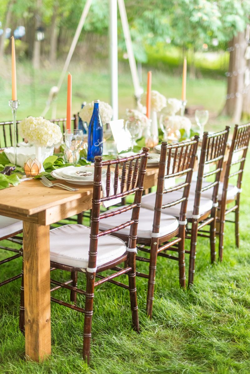 Saratoga Springs destination wedding photos in upstate New York by Mikkel Paige Photography, NY wedding photographer. The bride and groom tented a lawn for their reception. They had wood Chiavari chairs, milk glass and vintage salt and pepper shakers on each table. The table numbers were destinations the couple had been. #mikkelpaige #saratogaspringswedding #destinationwedding #lakefrontwedding #waterfrontwedding #lakewedding #tablenumbers #weddingreception #intimatewedding