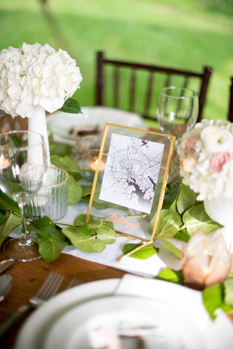 Saratoga Springs destination wedding photos in upstate New York by Mikkel Paige Photography, NY wedding photographer. The bride and groom tented a lawn for their reception. They had wood Chiavari chairs, milk glass and vintage salt and pepper shakers on each table. The table numbers were destinations the couple had been. #mikkelpaige #saratogaspringswedding #destinationwedding #lakefrontwedding #waterfrontwedding #lakewedding #tablenumbers #weddingreception #intimatewedding