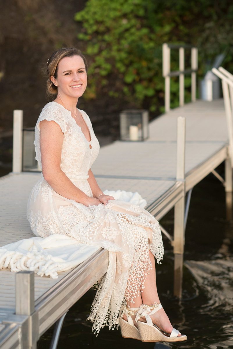 Saratoga Springs destination wedding photos in upstate New York by Mikkel Paige Photography, NY wedding photographer. The bride wore a boho lace gown and sat on the dock at the lake for a playful bridal portrait. #mikkelpaige #saratogaspringswedding #destinationwedding #bridestyle #bridalportrait #lakefrontwedding #lakewedding