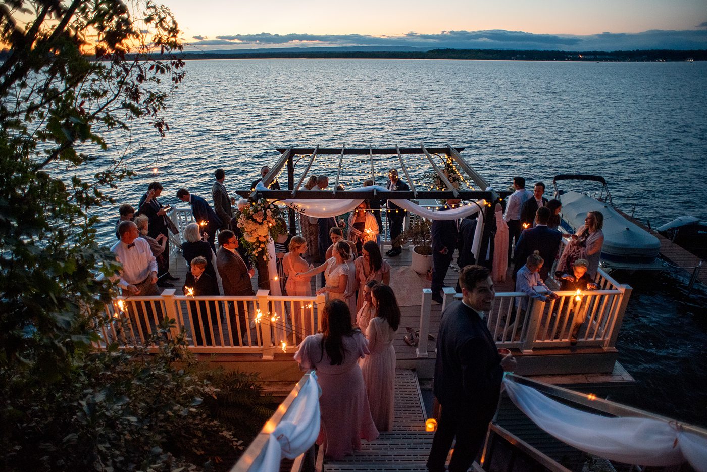 Saratoga Springs destination wedding photos in upstate New York by Mikkel Paige Photography, NY wedding photographer. The bride and groom tented a home for their reception. Guests lit sparklers at dusk after sun set on Saratoga Lake. #mikkelpaige #saratogaspringswedding #destinationwedding #lakefrontwedding #waterfrontwedding #lakewedding #tablenumbers #weddingreception #intimatewedding #sparklers