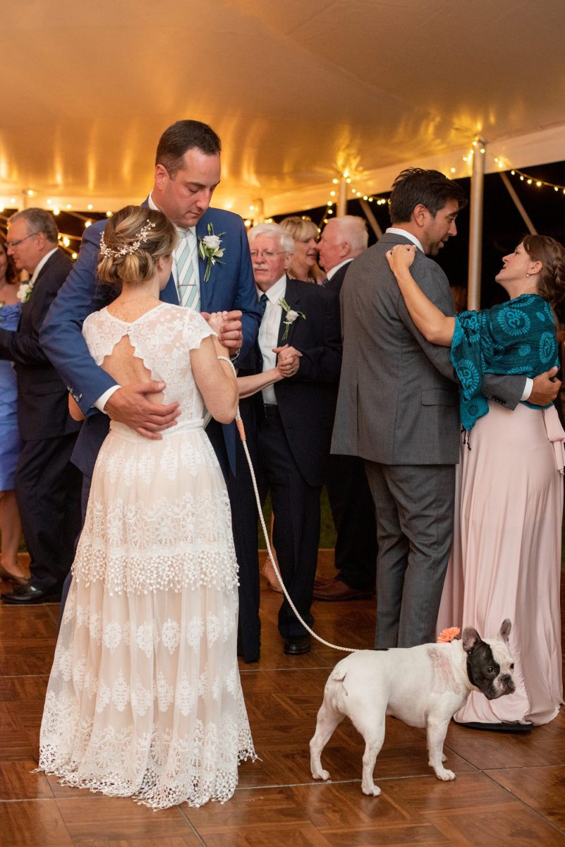 Saratoga Springs destination wedding photos in upstate New York by Mikkel Paige Photography, NY wedding photographer. The bride and groom tented a home for their reception. They had wood Chiavari chairs, milk glass and vintage salt and pepper shakers on each table. The table numbers were destinations the couple had been. #mikkelpaige #saratogaspringswedding #destinationwedding #lakefrontwedding #waterfrontwedding #lakewedding #tablenumbers #weddingreception #intimatewedding