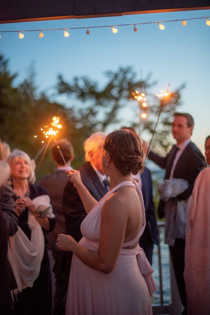 Saratoga Springs destination wedding photos in upstate New York by Mikkel Paige Photography, NY wedding photographer. The bride and groom tented a home for their reception. Guests lit sparklers at dusk after sun set on Saratoga Lake. #mikkelpaige #saratogaspringswedding #destinationwedding #lakefrontwedding #waterfrontwedding #lakewedding #tablenumbers #weddingreception #intimatewedding #sparklers