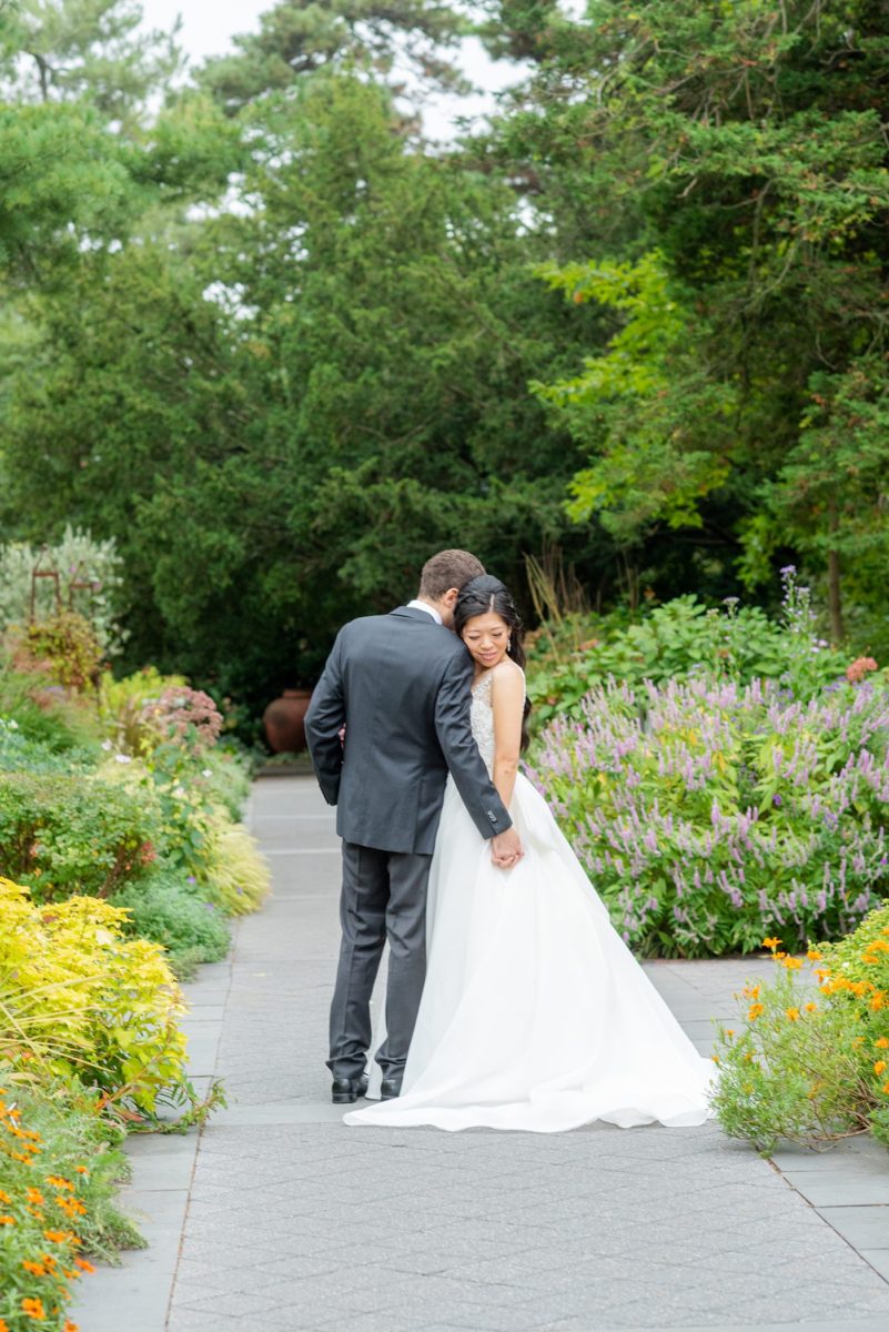 New York Botanical Garden wedding photos by Mikkel Paige Photography. The groom wore a green tie with floral detail and gray suit and bride a beaded ballgown with bow on the back. After the couple's engagement photoshoot in Manhattan I was so excited for their fall wedding near the Conservatory at the Terrace Room, at this NYC venue. #mikkelpaige #nybg #asianbride #bridestyle #brideandgroom #newyorkbotanicalgardenwedding #groomstyle #NYBotanicalGarden #Bronxwedding #newyorkcityweddingvenue