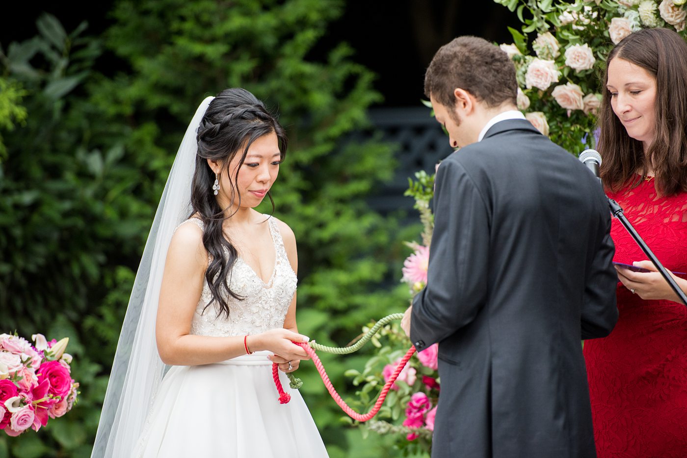 Outdoor ceremony at a New York Botanical Garden wedding photos by Mikkel Paige Photography. After the couple's engagement photoshoot in Manhattan I was so excited for their fall wedding near the Conservatory at the Terrace Room, at this NYC venue. Their backdrop was an ombre flower circle with pink and red blooms. #mikkelpaige #nybg #newyorkbotanicalgardenwedding #asianbride #NYBotanicalGarden #Bronxwedding #newyorkcityweddingvenues #weddingceremony #ombreflowers #tietheknot