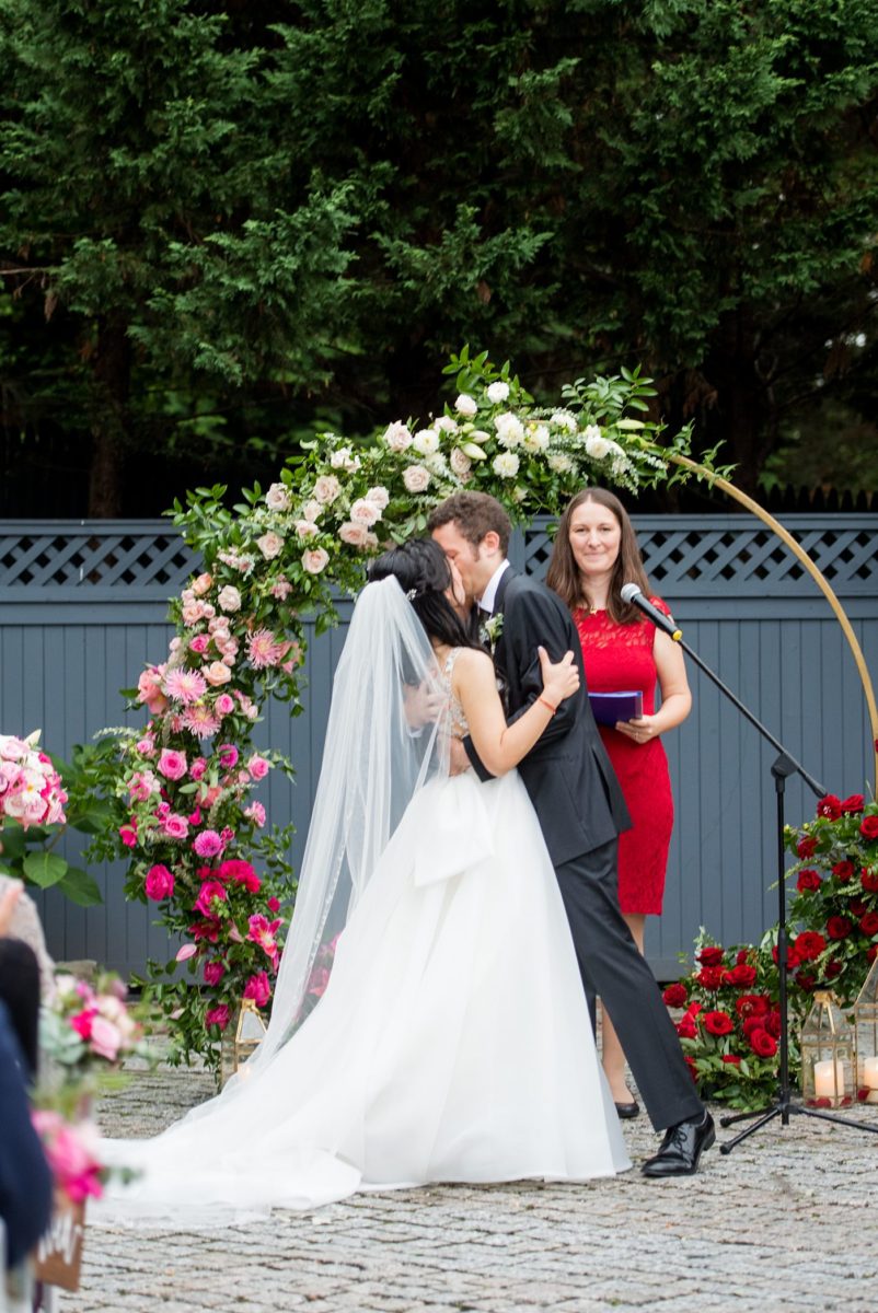 Outdoor ceremony at a New York Botanical Garden wedding photos by Mikkel Paige Photography. After the couple's engagement photoshoot in Manhattan I was so excited for their fall wedding near the Conservatory at the Terrace Room, at this NYC venue. Their backdrop was an ombre flower circle with pink and red blooms. #mikkelpaige #nybg #newyorkbotanicalgardenwedding #asianbride #NYBotanicalGarden #Bronxwedding #newyorkcityweddingvenues #weddingceremony #ombreflowers