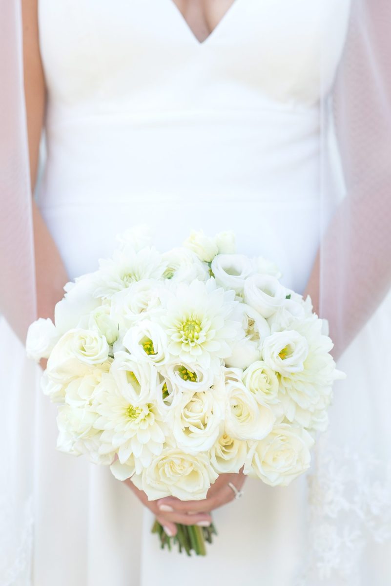 Photos by Mikkel Paige Photography at Waveny House wedding venue in New Canaan, Connecticut. This beautiful venue has an outdoor garden for the ceremony and indoor historic home for the reception. The bride wore a simple white gown with elaborate lace back. She carried an all white and ivory bouquet. #mikkelpaige #wavenyhouse #wavenyhousewedding #connecticutweddingvenue #connecticutweddingphotographer #bridestyle #whitebouquet #bridalportraits