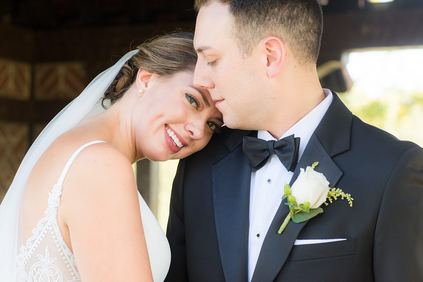 Photos by Mikkel Paige Photography at Waveny House wedding venue in New Canaan, Connecticut. This beautiful venue has an outdoor garden for the ceremony and indoor historic home for the reception. The bride and groom took photos on the park property, him in a tuxedo and her in a simple white gown with elaborate lace back. She carried an all white and ivory bouquet. #mikkelpaige #wavenyhouse #wavenyhousewedding #connecticutweddingvenue #connecticutweddingphotographer #brideandgroom #whitebouquet