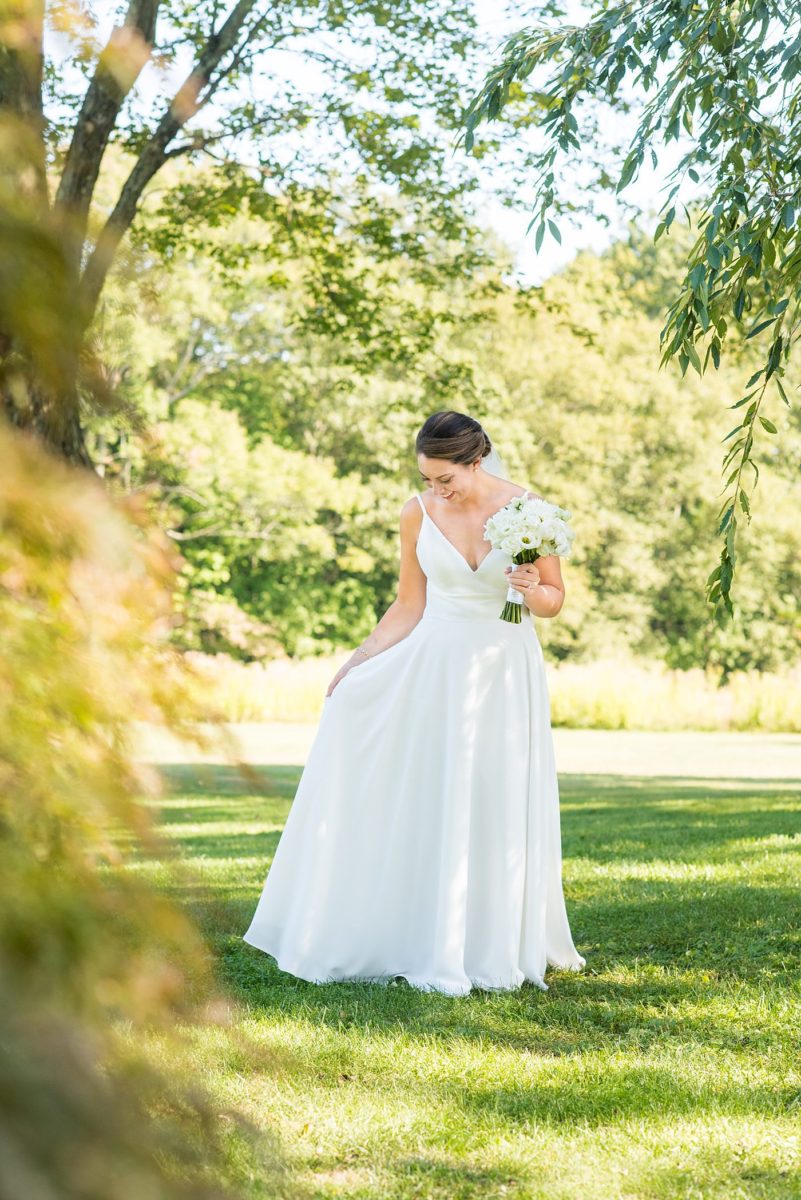 Photos by Mikkel Paige Photography at Waveny House wedding venue in New Canaan, Connecticut. This beautiful venue has an outdoor garden for the ceremony and indoor historic home for the reception. The bride wore a simple white gown with elaborate lace back. She carried an all white and ivory bouquet. #mikkelpaige #wavenyhouse #wavenyhousewedding #connecticutweddingvenue #connecticutweddingphotographer #bridestyle #whitebouquet #bridalportraits