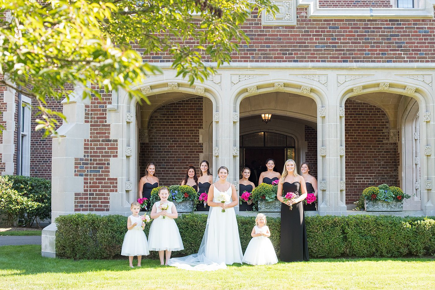 Bridal party photos by Mikkel Paige Photography at Waveny House wedding venue in New Canaan, Connecticut. This beautiful venue has an outdoor garden for the ceremony and indoor historic home for the reception. The bride wore an elegant, simple white gown and bridesmaids wore black dresses, with hot pink rose bouquets. #mikkelpaige #wavenyhouse #wavenyhousewedding #connecticutweddingvenue #connecticutweddingphotographer #bridalparty #bridesmaids #blackgowns #pinkbouquets