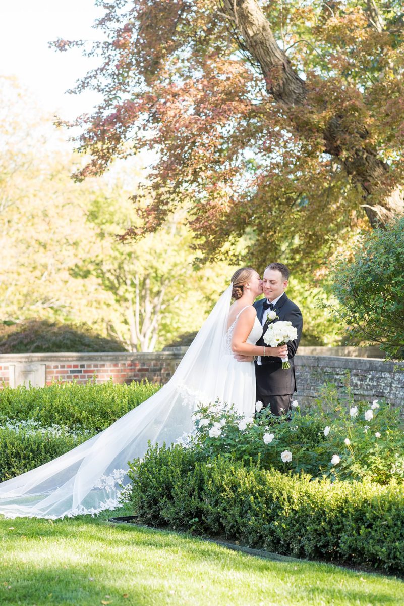 Photos by Mikkel Paige Photography at Waveny House wedding venue in New Canaan, Connecticut. This beautiful venue has an outdoor garden for the ceremony and indoor historic home for the reception. The bride and groom took photos on the park property, him in a tuxedo and her in a simple white gown with elaborate lace back. She carried an all white and ivory bouquet. #mikkelpaige #wavenyhouse #wavenyhousewedding #connecticutweddingvenue #connecticutweddingphotographer #brideandgroom #whitebouquet