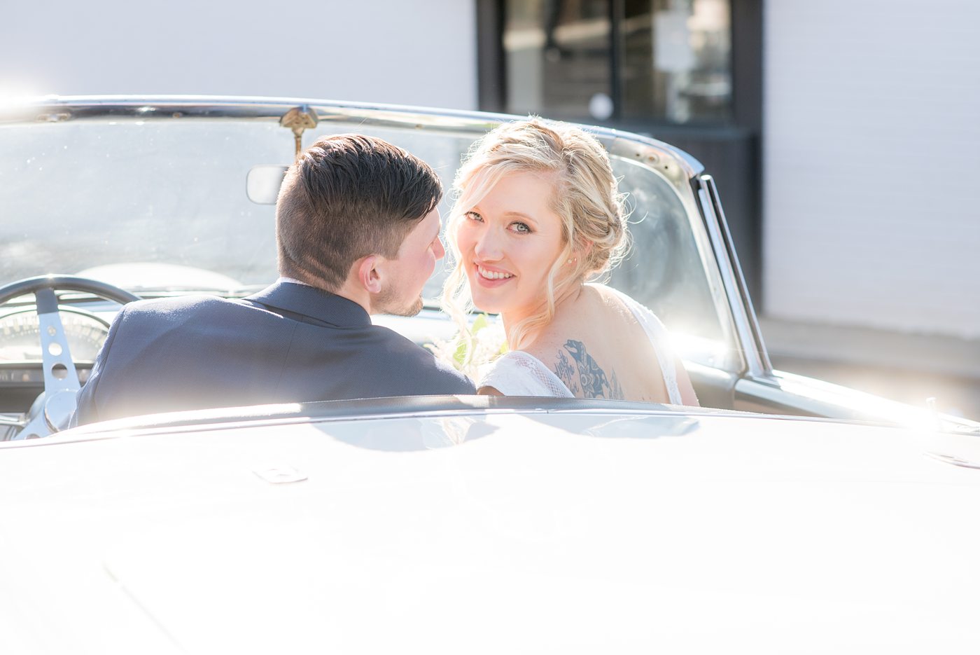 Chatham Station wedding photos by Mikkel Paige Photography from this urban chic beautiful venue in Cary, North Carolina. The bride wore a tulle v-neck gown and up hair-do with braids and groom a blue suit with custom details for a fall celebration. They took iconic photos with a vintage white Thunderbird car. #mikkelpaige #RaleighWeddingPhotographer #NorthCarolinaWeddings #SouthernWeddings #bridestyle #brideandgroom #vintagecar