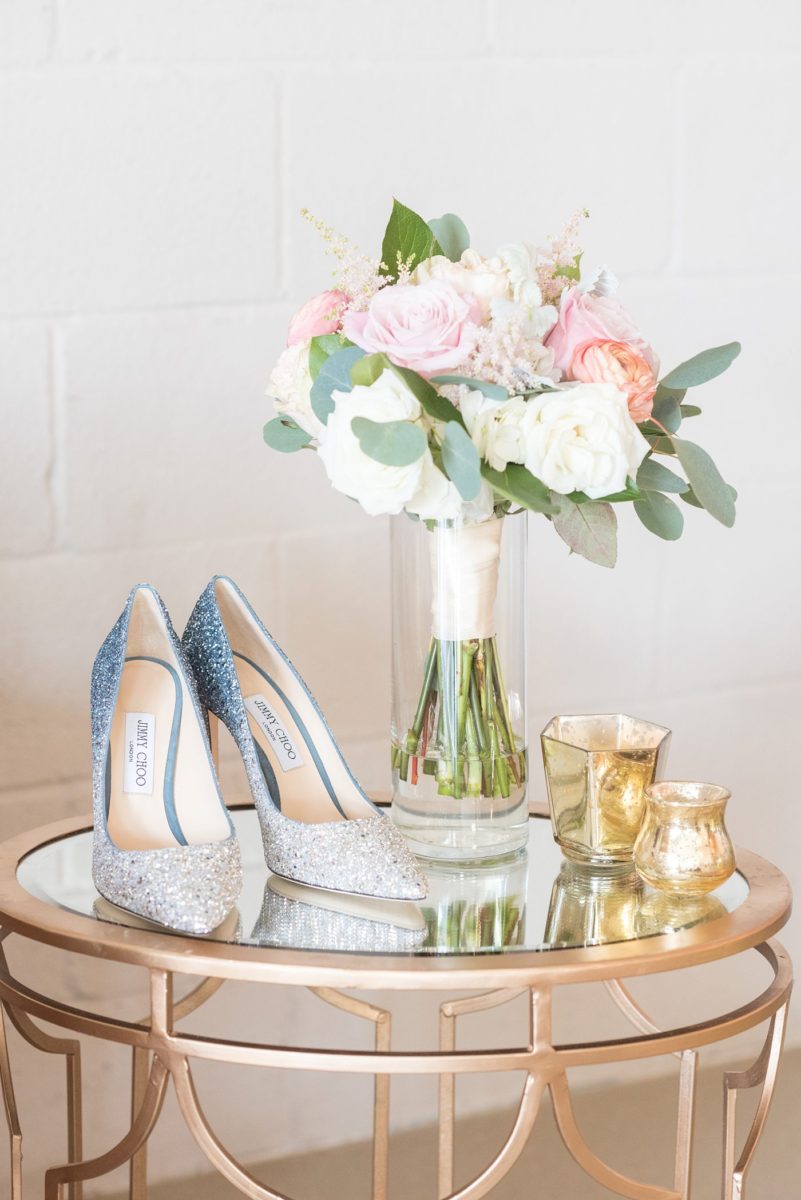 Detail photo of the bride's wedding day blue ombre glitter Jimmy Choo shoes and colorful bouquet at Chatham Station by Mikkel Paige Photography. This beautiful Cary, North Carolina venue has indoor and outdoor spaces. #mikkelpaige #RaleighWeddingPhotographer #NorthCarolinaWeddings #SouthernWeddings #bridestyle #weddingshoes #blueglitterheels #glittershoes #blueombre #ombreshoes