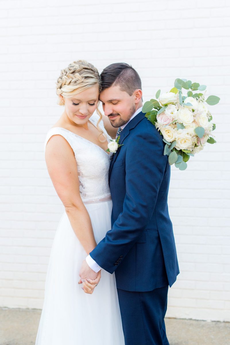 Chatham Station wedding photos by Mikkel Paige Photography from this urban chic beautiful venue in Cary, North Carolina. The bride wore a white tulle v-neck gown and up hair-do with braids and groom a blue suit with custom details for a fall celebration. #mikkelpaige #RaleighWeddingPhotographer #NorthCarolinaWeddings #SouthernWeddings #bridestyle #brideandgroom