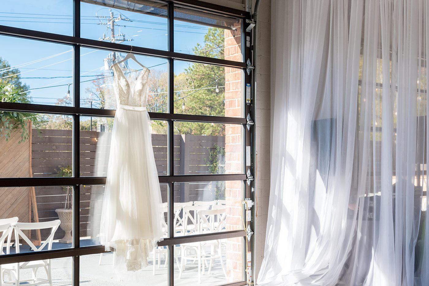 Chatham Station wedding photos by Mikkel Paige Photography from this urban chic beautiful venue in Cary, North Carolina. The bride wore a white tulle v-neck gown and up hair-do with braids and groom a blue suit with custom details for a fall celebration. #mikkelpaige #RaleighWeddingPhotographer #NorthCarolinaWeddings #SouthernWeddings #bridestyle #brideandgroom