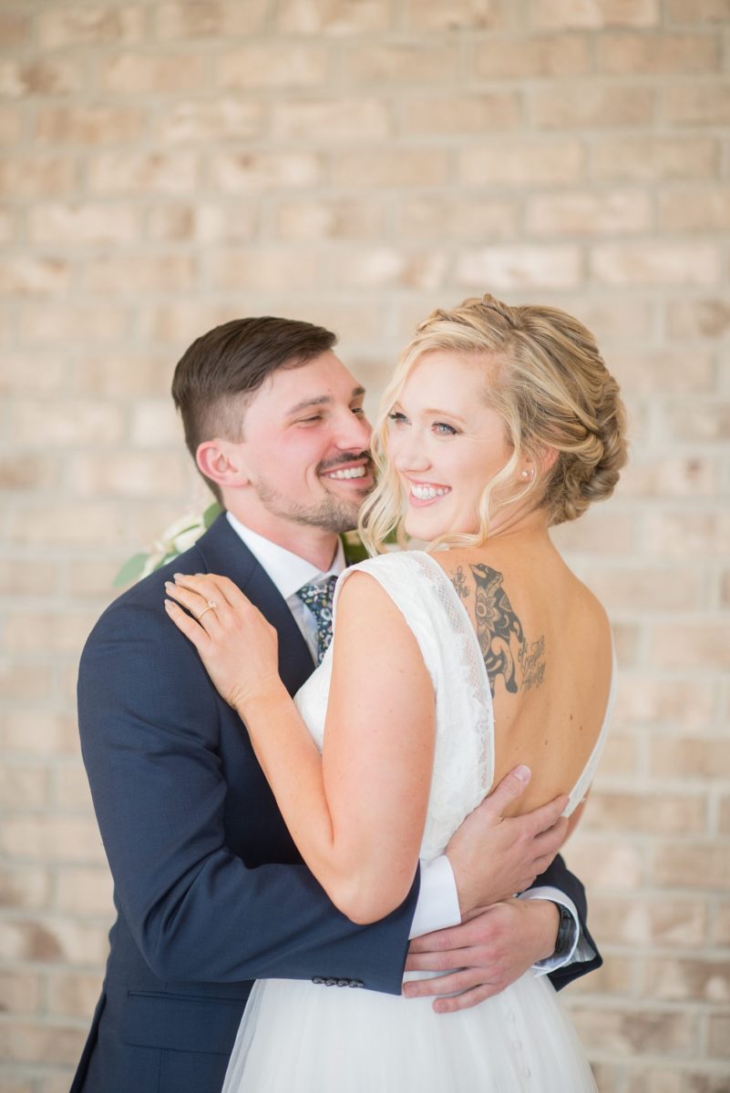 Chatham Station wedding photos by Mikkel Paige Photography from this urban chic beautiful venue in Cary, North Carolina. The bride wore a white tulle v-neck gown and up hair-do with braids and groom a blue suit with custom details for a fall celebration. #mikkelpaige #RaleighWeddingPhotographer #NorthCarolinaWeddings #SouthernWeddings #bridestyle #brideandgroom