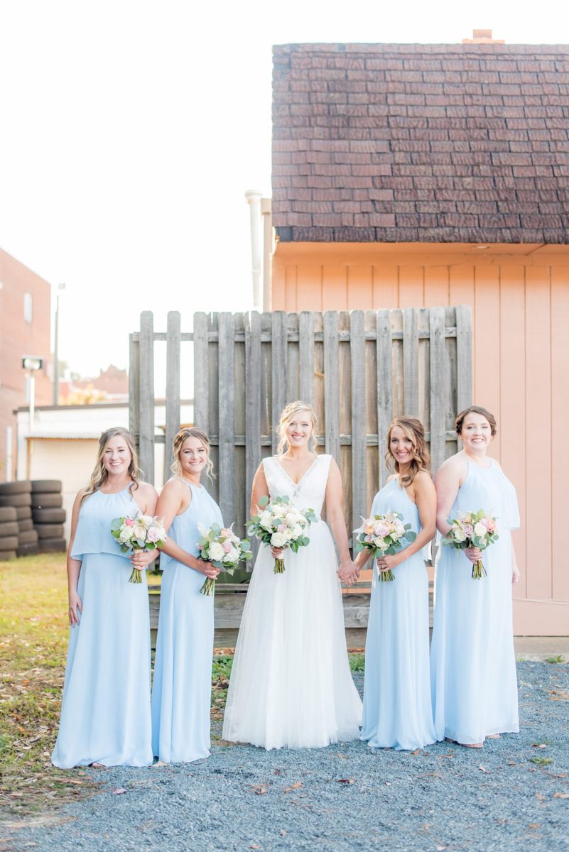 Chatham Station wedding photos by Mikkel Paige Photography from this urban chic beautiful venue in Cary, North Carolina. The bride wore a white tulle v-neck gown, bridesmaids in baby blue gowns and groom and groomsmen in blue suits with custom details for a fall celebration. #mikkelpaige #RaleighWeddingPhotographer #NorthCarolinaWeddings #SouthernWeddings #bridestyle #brideandgroom #bridalparty #lightbluegowns #bluebridesmaids #babybluewedding #lightbluewedding