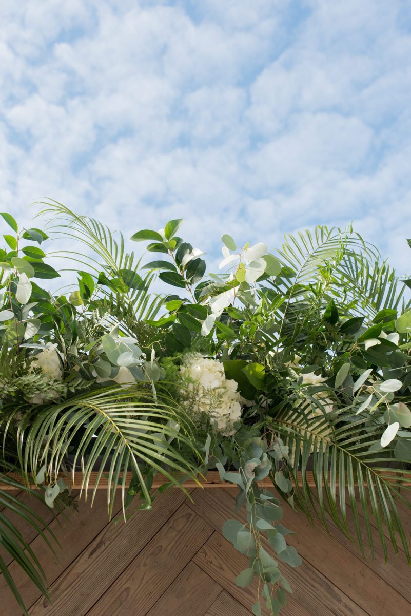 Detail photo of tropical leaves for a ceremony backdrop at Chatham Station by Mikkel Paige Photography. This beautiful Cary, North Carolina venue has indoor and outdoor spaces. #mikkelpaige #RaleighWeddingPhotographer #NorthCarolinaWeddings #SouthernWeddings #weddingceremony #tropicalleaves