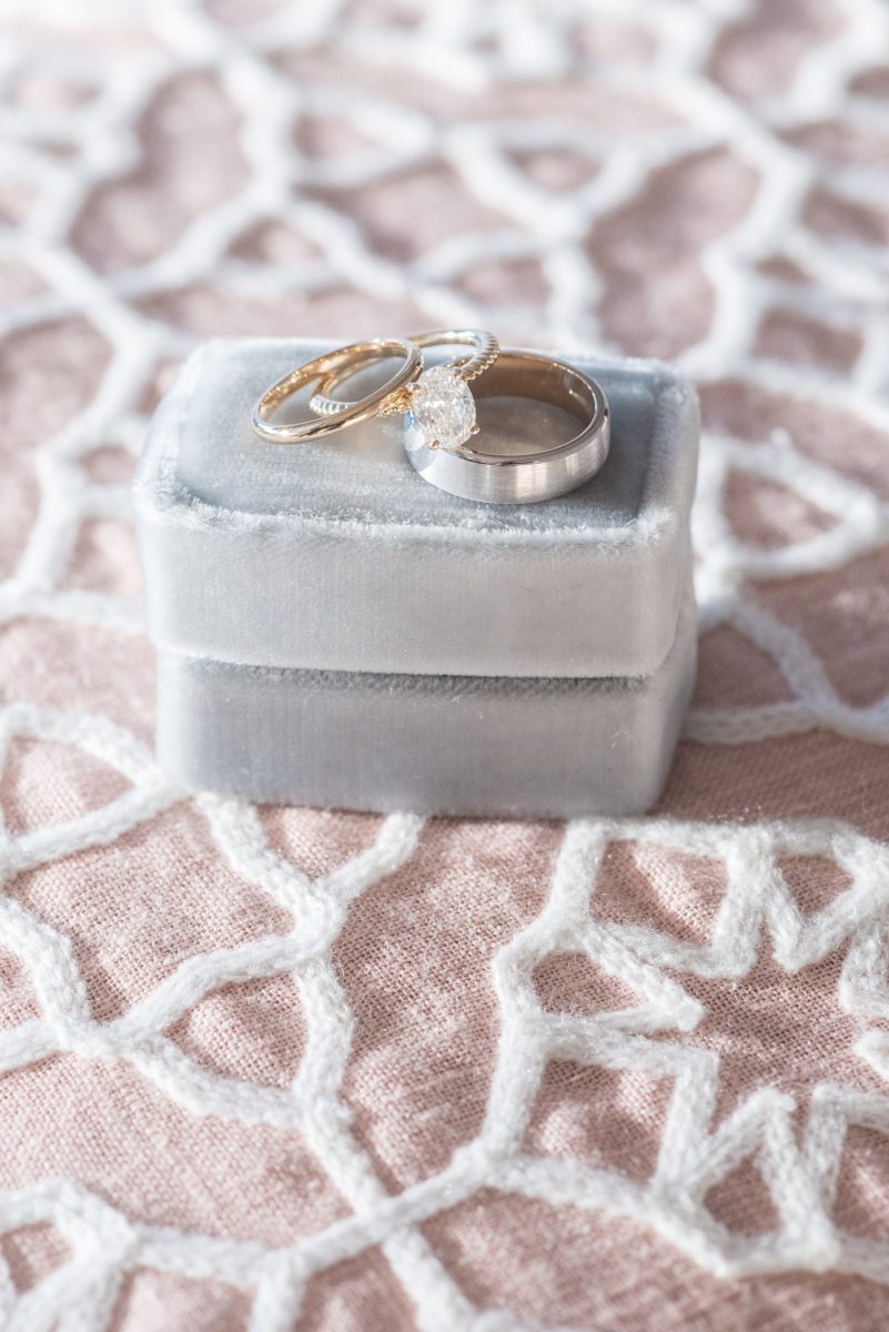 Detail photo of gold diamond rings on a blue velvet ring box at Chatham Station by Mikkel Paige Photography. This beautiful Cary, North Carolina venue has indoor and outdoor spaces. #mikkelpaige #RaleighWeddingPhotographer #NorthCarolinaWeddings #SouthernWeddings #weddingrings #velvetringbox