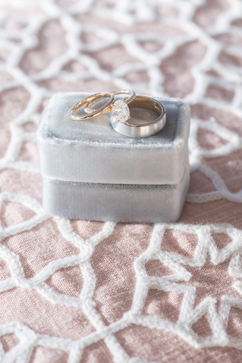 Detail photo of gold diamond rings on a blue velvet ring box at Chatham Station by Mikkel Paige Photography. This beautiful Cary, North Carolina venue has indoor and outdoor spaces. #mikkelpaige #RaleighWeddingPhotographer #NorthCarolinaWeddings #SouthernWeddings #weddingrings #velvetringbox