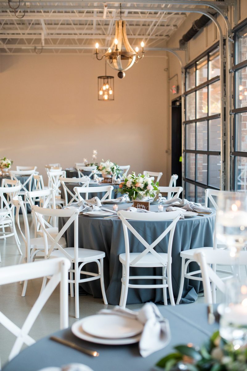 Fall photos at Cary, North Carolina wedding venue Chatham Station by Mikkel Paige Photography. The reception was filled with round tables, white cross-back chairs, grey linens and floral centerpieces. Candlelight filled the room and there were couches and velvet pillows for lounge areas. #mikkelpaige #RaleighWeddingPhotographer #NorthCarolinaWeddings #SouthernWeddings #fallwedding #RaleighWedding #CaryNorthCarolina #weddinglounge #weddingreception #greyandpinkwedding