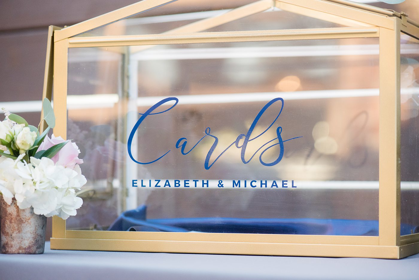 Fall photos at Cary, North Carolina wedding venue Chatham Station by Mikkel Paige Photography. This urban, beautiful space has an indoor and outdoor space near Raleigh. This detail photo shows the blue calligraphy on their glass card box. #mikkelpaige #RaleighWeddingPhotographer #NorthCarolinaWeddings #SouthernWeddings #fallwedding #RaleighWedding #CaryNorthCarolina #weddingdetails #cardbox #glasscardbox