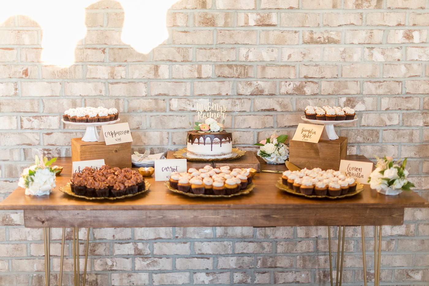 Fall photos at Cary, North Carolina wedding venue Chatham Station by Mikkel Paige Photography. This urban, beautiful space has an indoor and outdoor space near Raleigh. The bride and groom had a small chocolate covered gluten free cake with a custom name topper with mini-cupcakes surrounding it. #mikkelpaige #RaleighWeddingPhotographer #NorthCarolinaWeddings #SouthernWeddings #fallwedding #RaleighWedding #CaryNorthCarolina #weddingcake #smallweddingcake