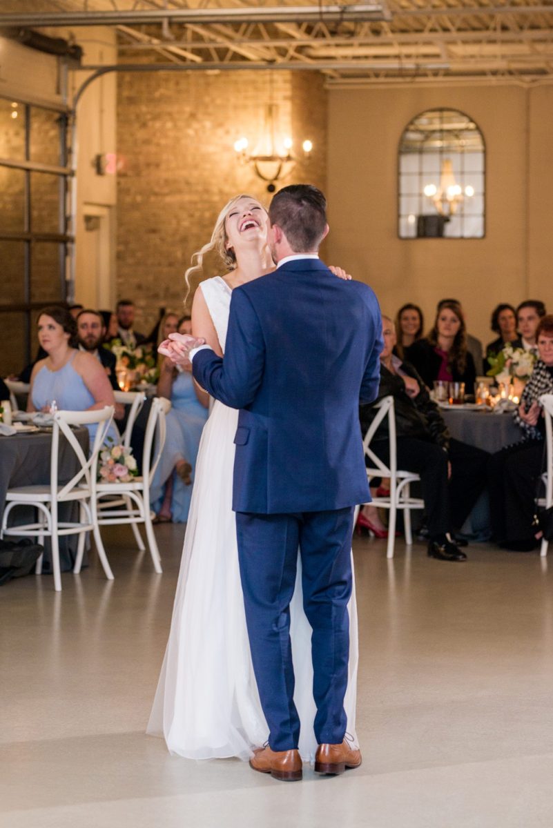 Fall photos at Cary, North Carolina wedding venue Chatham Station by Mikkel Paige Photography. This urban, beautiful space has an indoor and outdoor space near Raleigh. A DJ played as guests looked on during their reception as the bride and groom danced their first dance. #mikkelpaige #RaleighWeddingPhotographer #NorthCarolinaWeddings #SouthernWeddings #fallwedding #RaleighWedding #CaryNorthCarolina