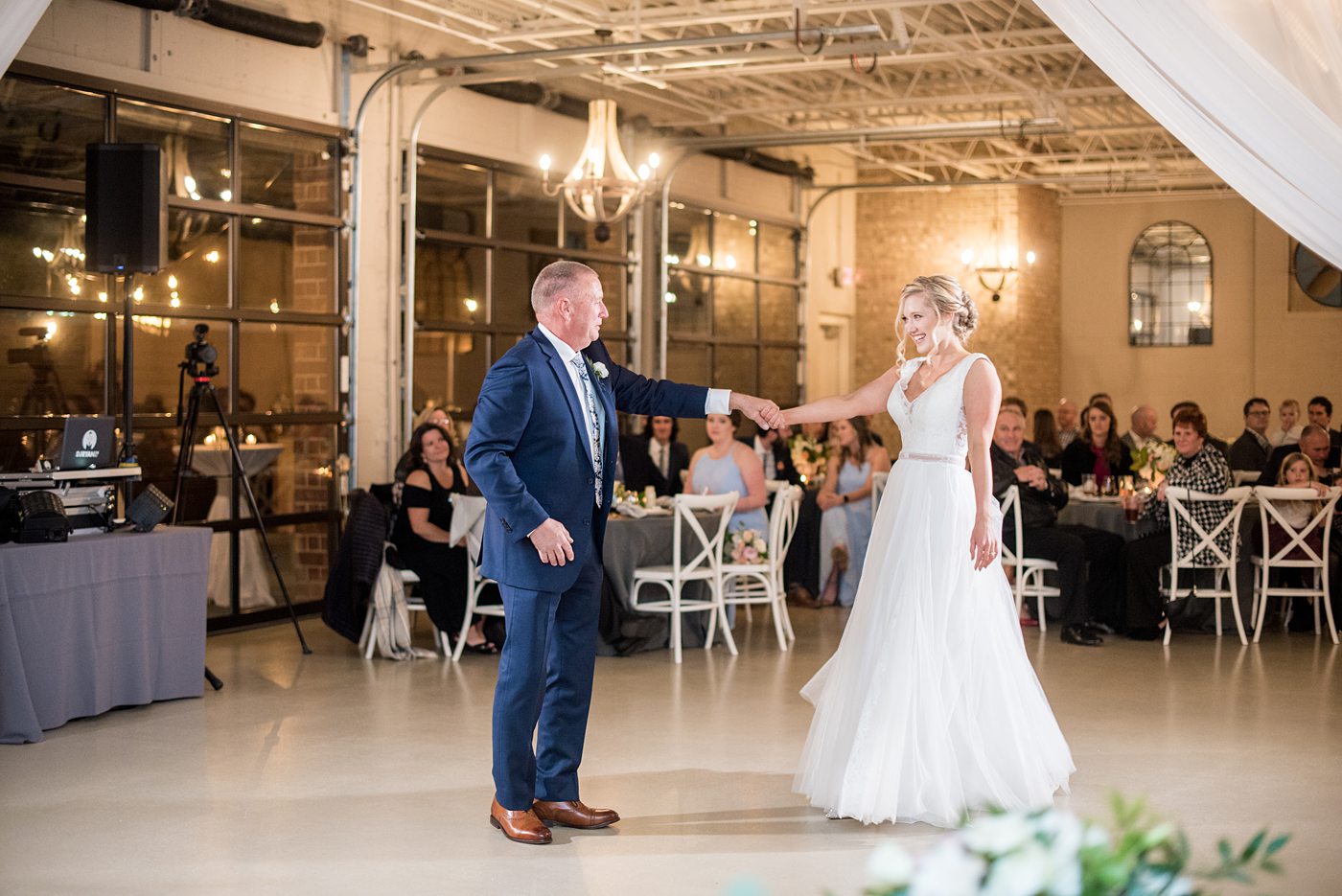 Fall photos at Cary, North Carolina wedding venue Chatham Station by Mikkel Paige Photography. This urban, beautiful space has an indoor and outdoor space near Raleigh. A DJ played as guests looked on during their reception as the bride and father of the bride danced. #mikkelpaige #RaleighWeddingPhotographer #NorthCarolinaWeddings #SouthernWeddings #fallwedding #RaleighWedding #CaryNorthCarolina