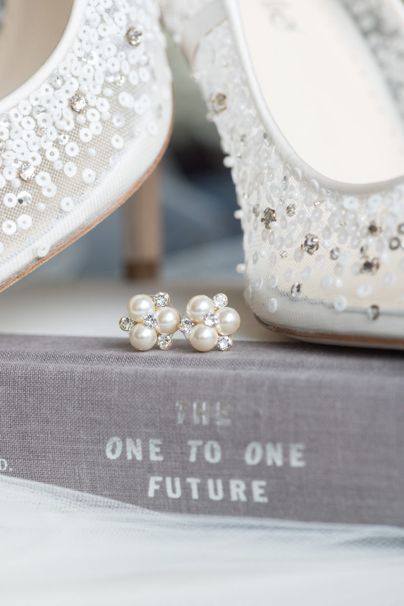 Wedding photographer Mikkel Paige Photography captures a ceremony at Duke Chapel and reception at The Rickhouse, a beautiful downtown venue in Durham, North Carolina. The bride and groom got ready at the JB Duke Hotel. Photo of details of the pearl earrings and bride's high heel shoes. #durhamweddingphotographer #DukeChapelWedding #DurhamWeddingNorthCarolina #DurhamWeddingPhootgrapher #MikkelPaige #bridestyle