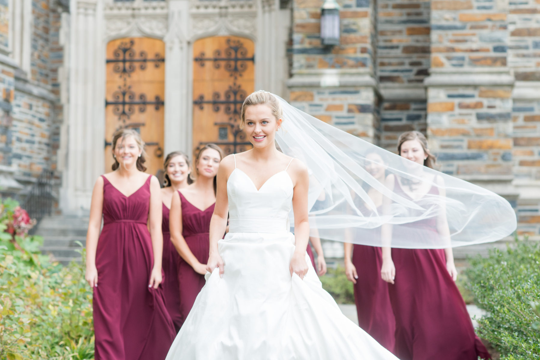 Wedding photographer Mikkel Paige Photography captures a ceremony at Duke Chapel and reception at The Rickhouse, a beautiful downtown venue in Durham, North Carolina. The bridesmaids wore maroon red, chiffon dresses and bride a v-neck white dupioni silk gown. #durhamweddingphotographer #DukeChapelWedding #DurhamWeddingNorthCarolina #DurhamWeddingPhotographer #MikkelPaige #bridesmaids #burgundywedding #maroonwedding