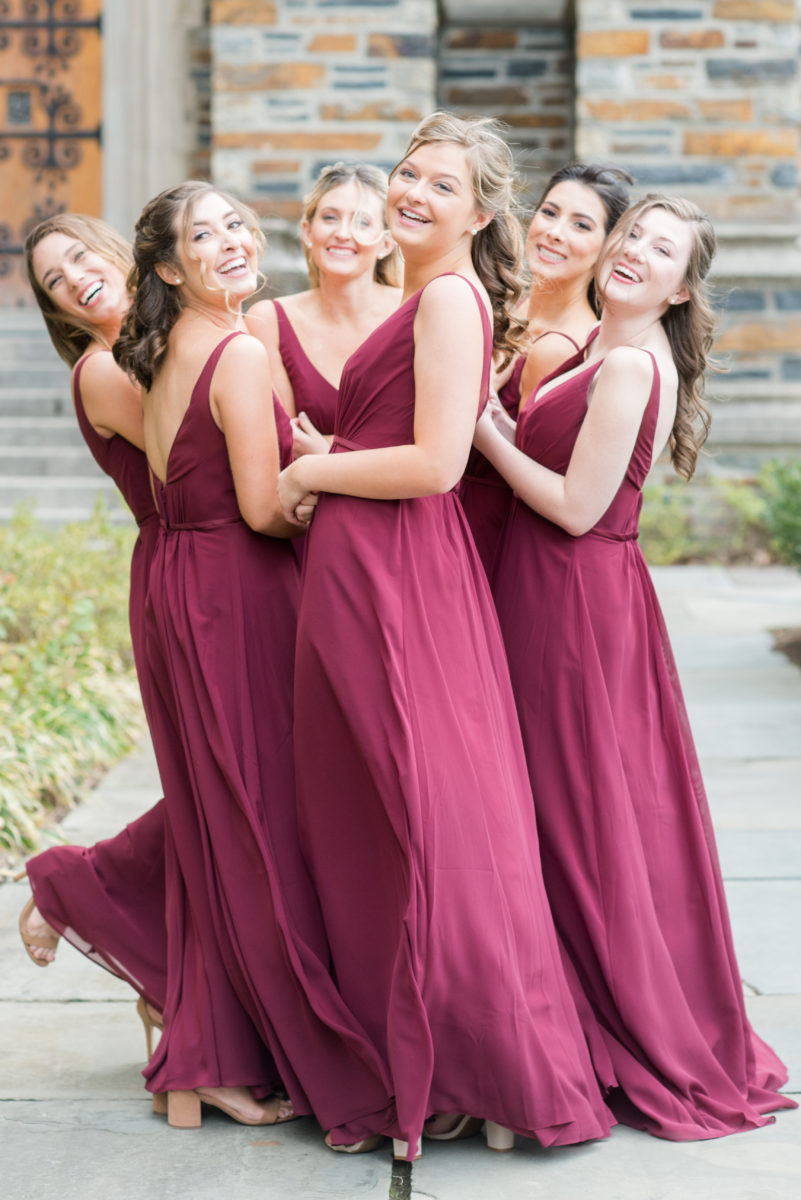 Wedding photographer Mikkel Paige Photography captures a ceremony at Duke Chapel and reception at The Rickhouse, a beautiful downtown venue in Durham, North Carolina. The bridesmaids wore maroon red, chiffon dresses and bride a v-neck white dupioni silk gown. #durhamweddingphotographer #DukeChapelWedding #DurhamWeddingNorthCarolina #DurhamWeddingPhotographer #MikkelPaige #bridesmaids #burgundywedding #maroonwedding