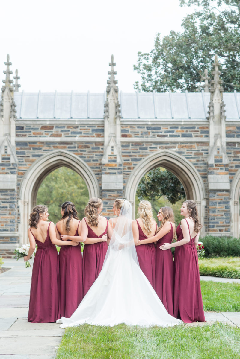 Wedding photographer Mikkel Paige Photography captures a ceremony at Duke Chapel and reception at The Rickhouse, a beautiful downtown venue in Durham, North Carolina. The bridesmaids wore maroon red, chiffon dresses and bride a v-neck white dupioni silk gown. #durhamweddingphotographer #DukeChapelWedding #DurhamWeddingNorthCarolina #DurhamWeddingPhotographer #MikkelPaige #bridesmaids #burgundywedding #maroonwedding