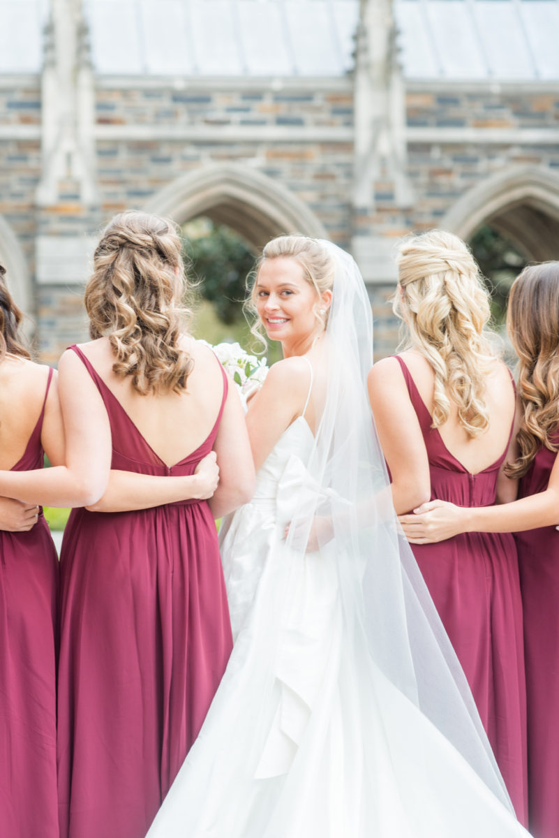 Wedding photographer Mikkel Paige Photography captures a ceremony at Duke Chapel and reception at The Rickhouse, a beautiful downtown venue in Durham, North Carolina. The bridesmaids wore maroon red, chiffon dresses and bride a v-neck white dupioni silk gown. #durhamweddingphotographer #DukeChapelWedding #DurhamWeddingNorthCarolina #DurhamWeddingPhotographer #MikkelPaige #bridesmaids #burgundywedding #maroonwedding