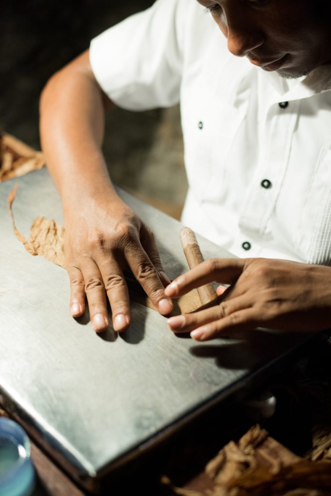Casa de Campo wedding photos in the Dominican Republic with outdoor ceremony. Pictures of the cigar roller at the reception by Mikkel Paige Photography.