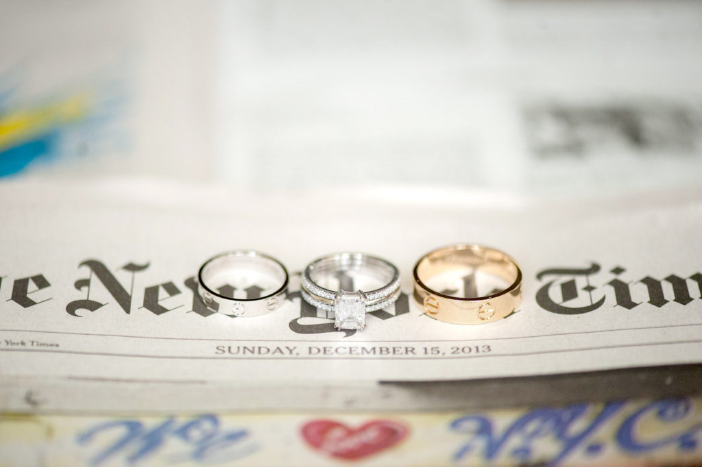 Walt Disney World wedding photographer capturing the rings on the New York Times for the couple's wedding day. This destination wedding was photographed by Mikkel Paige Photography at the Boardwalk hotel.