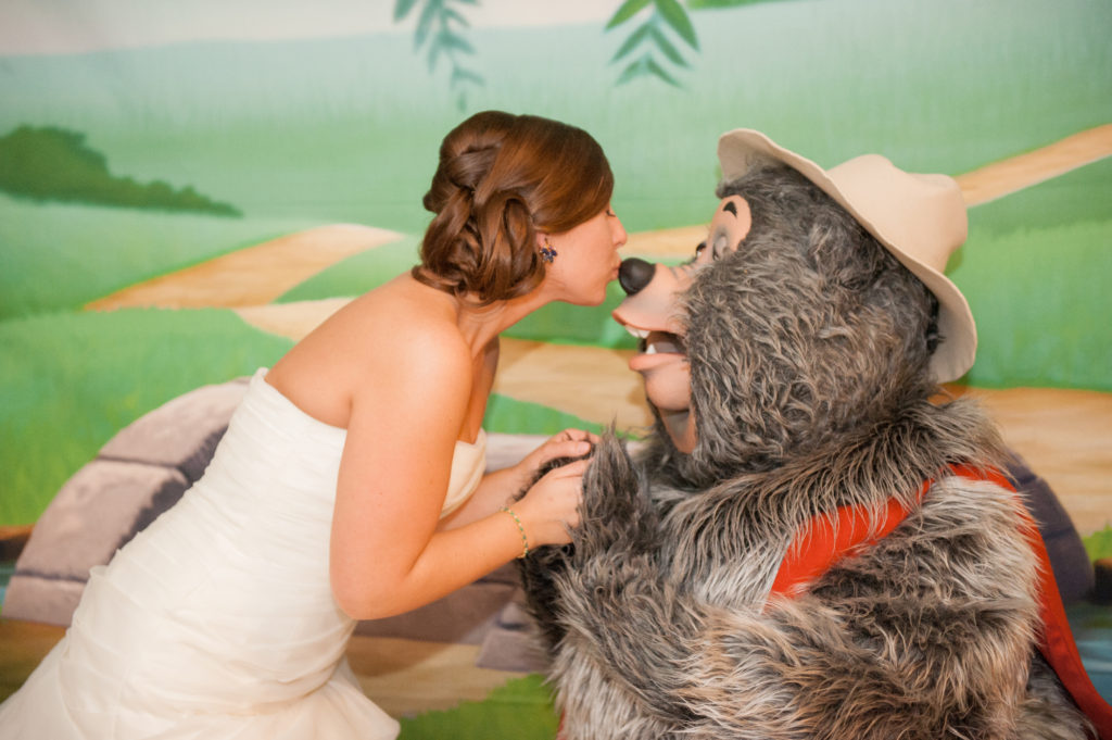 Walt Disney World wedding photographer capturing the bride kissing Big Al from Country Bear Jamboree at Atlantic Dance Hall. This destination wedding was photographed by Mikkel Paige Photography.