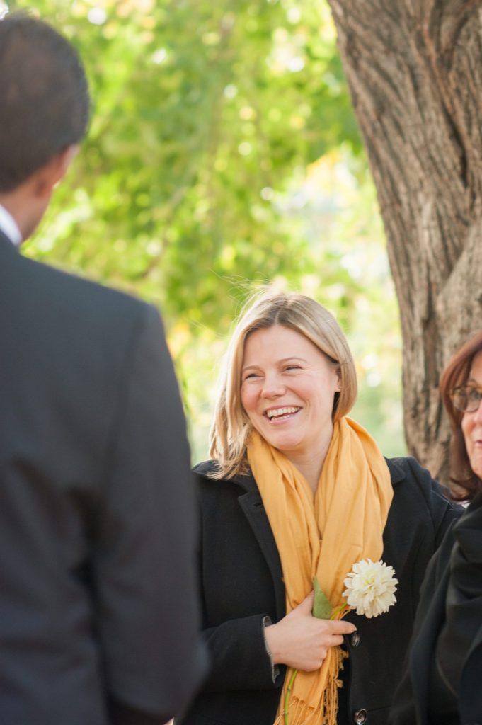 Best friend of the bride looks on during a small Brooklyn wedding elopement in NYC during Fall. Photos by Mikkel Paige Photography with a ceremony held at Fort Greene Park.