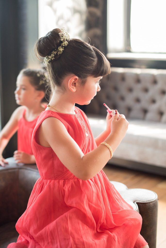 A 501 Union wedding in Brooklyn with photos by Mikkel Paige Photography. A flower girl applies lip gloss for a super cute candid picture!